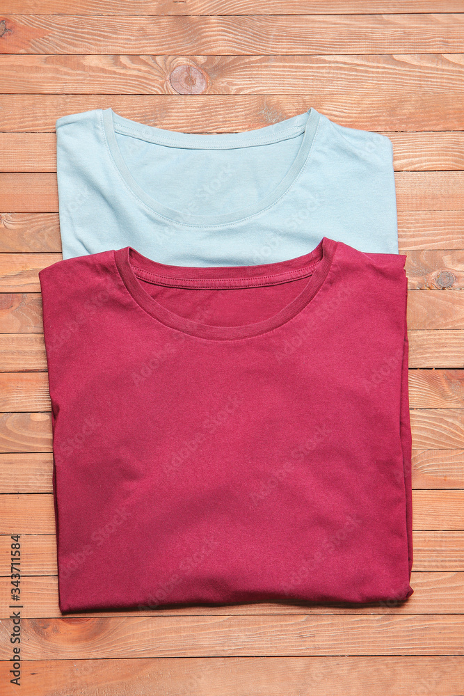 Different stylish t-shirts on wooden background