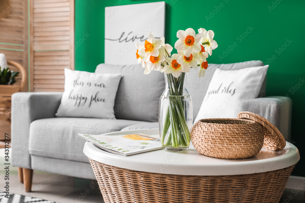 Beautiful spring flowers on table in interior of living room