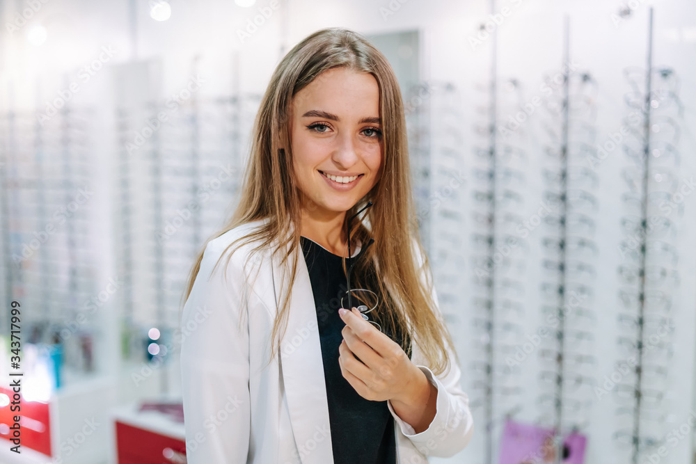 Eyeglasses shop. Woman with sunglasses. Choosing glasses. Client in optics. Selective focus. Stand w