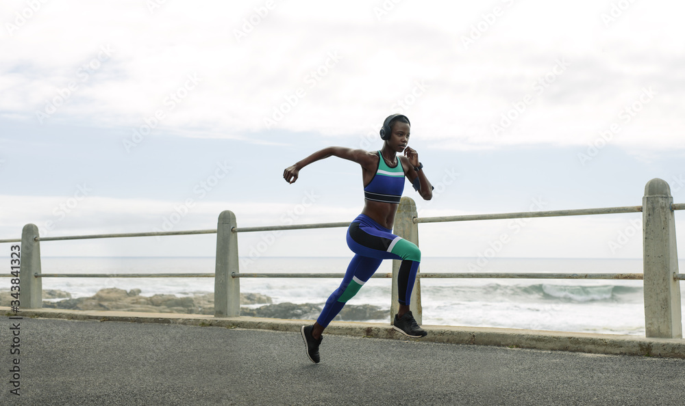 Athletic woman running on seaside promenade