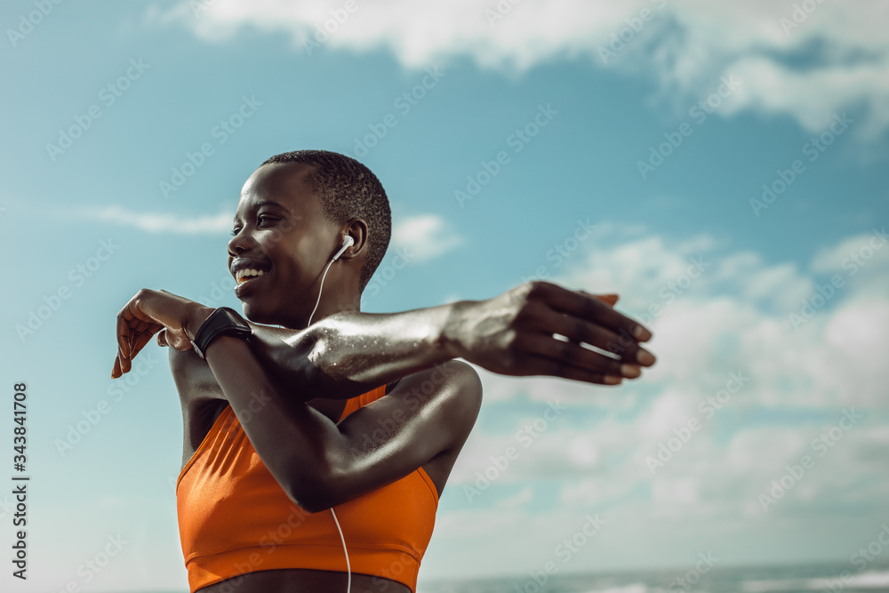 Female runner stretching hands at the beach