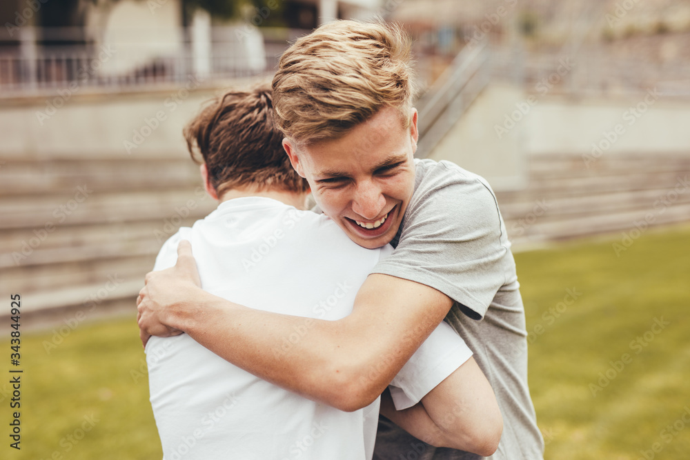 High school students greeting each other with a hug