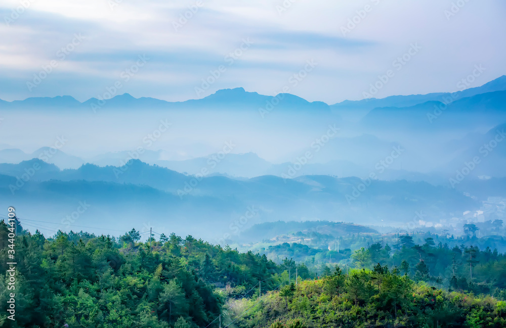 Mountain range with visible silhouettes through the morning colorful fog.