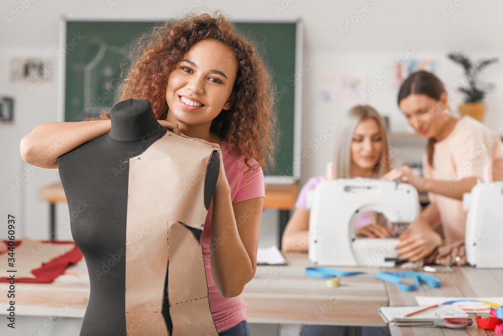 Young woman near mannequin during tailors class in atelier