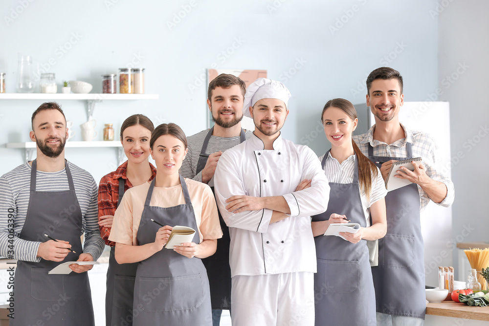 Male chef and group of young people during cooking classes