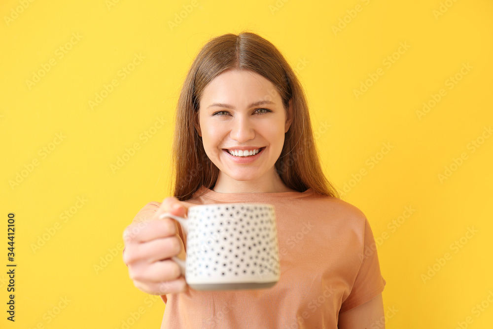 Young woman with coffee on color background