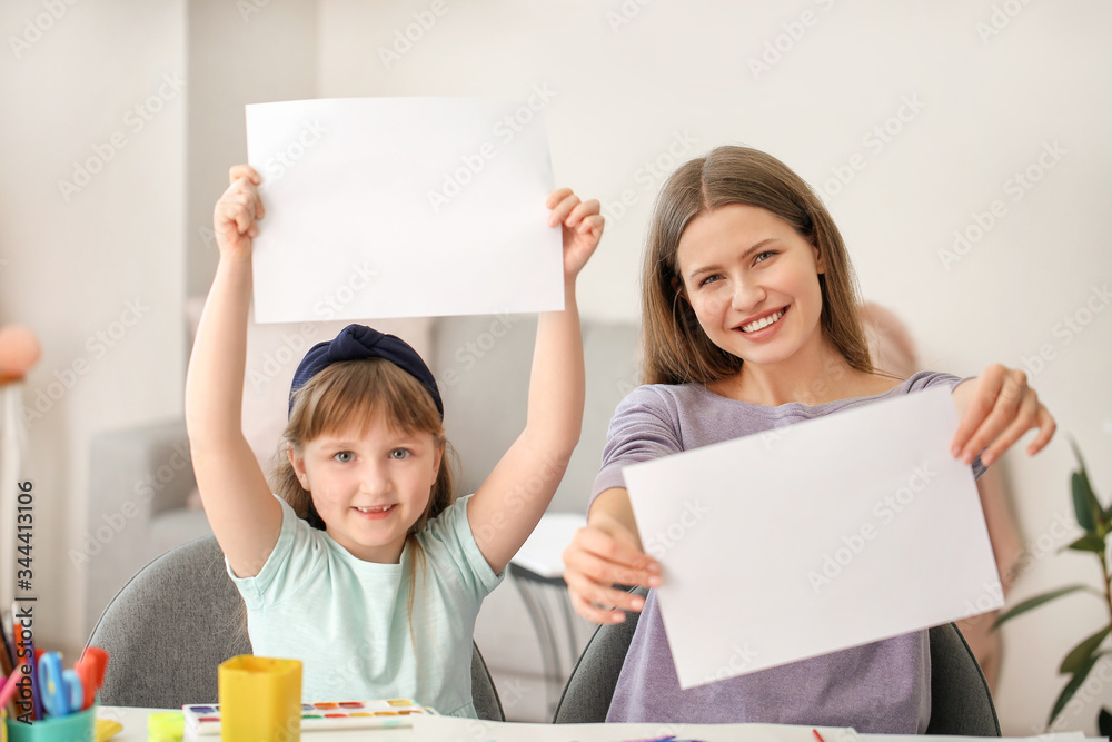 Drawing teacher giving private art lessons to little girl at home