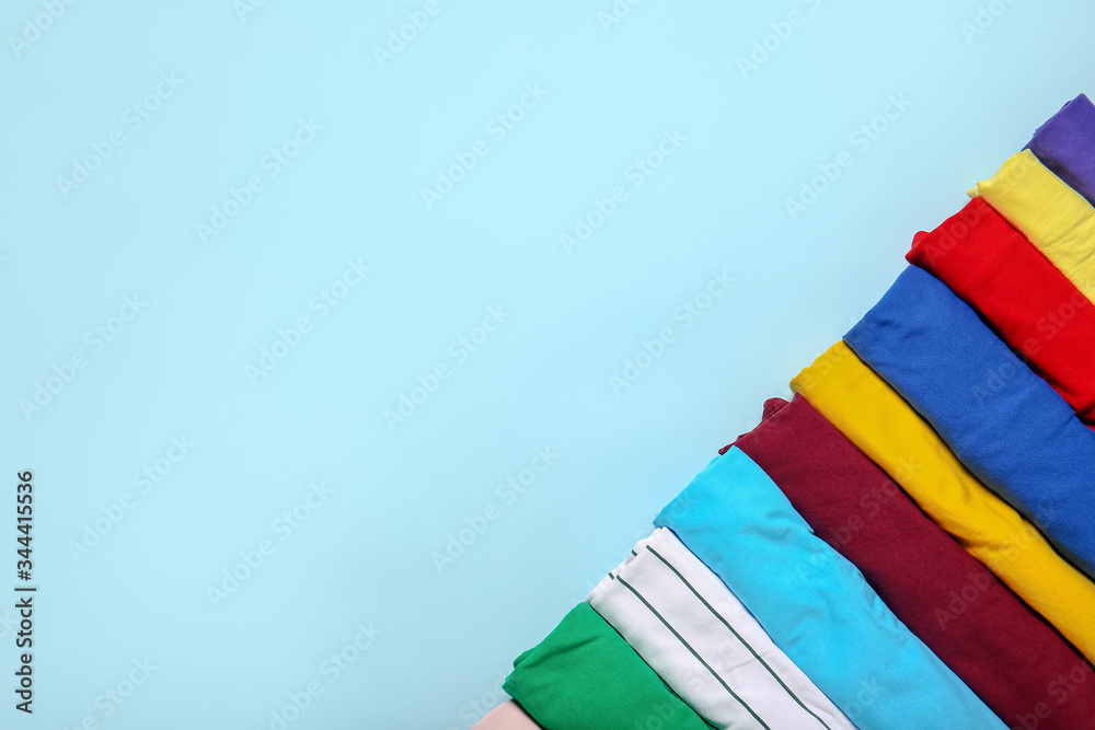 Stylish t-shirts on color background