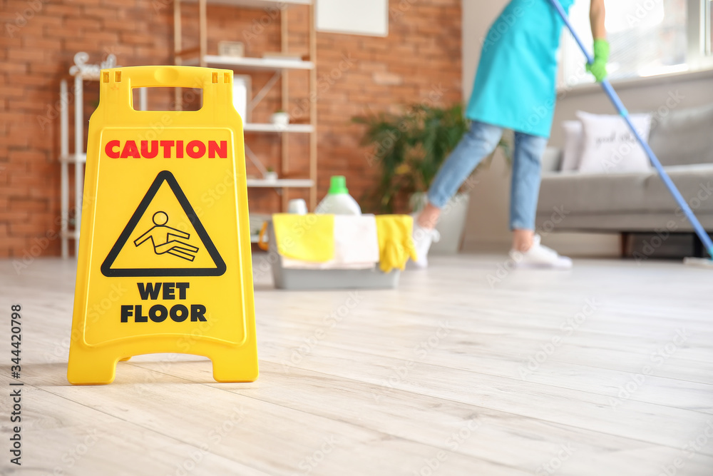 Caution sign with text WET FLOOR in room