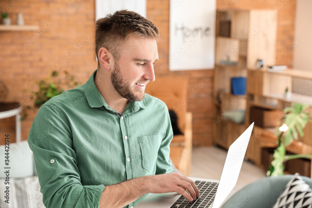 Young man with laptop working at home