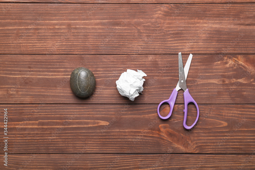 Scissors, rock and paper on wooden background