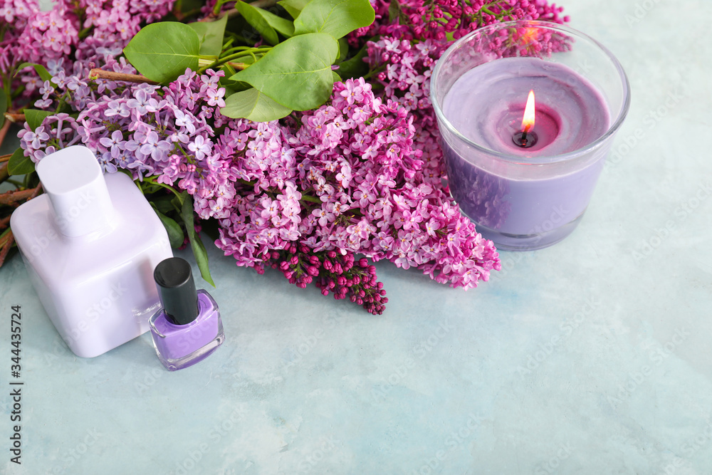 Beautiful lilac flowers, candle and cosmetics on table