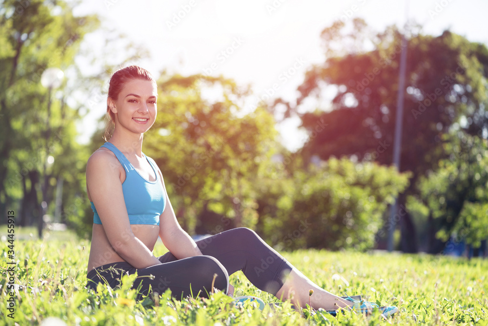 Beautiful smiling girl in sportswear relax in park