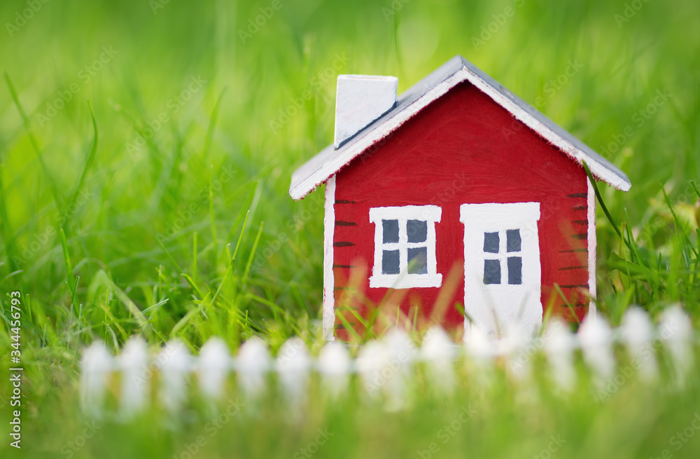 red wooden house model on the grass