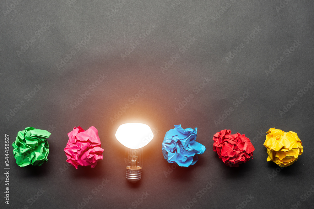 Lightbulb and crumpled colorful paper balls