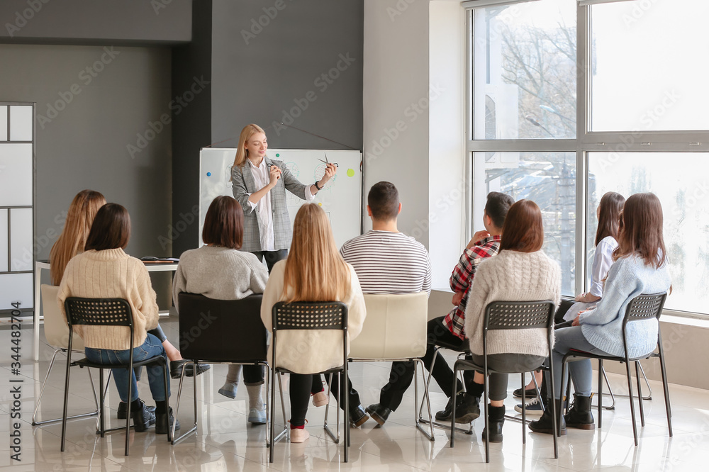 Professional hairdresser teaching young people in office