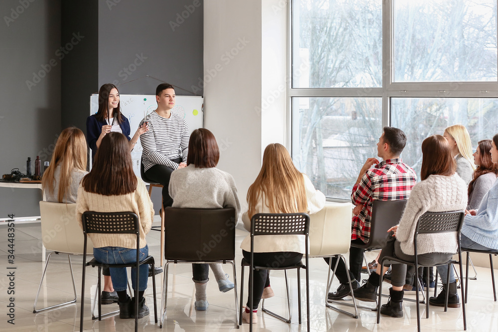 Professional hairdresser teaching young people in office