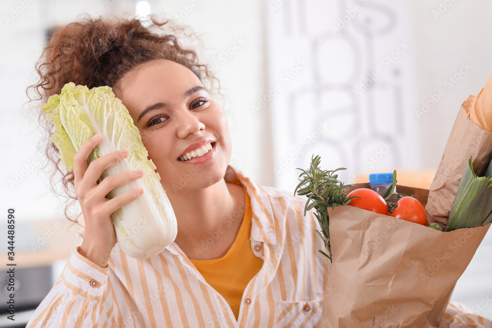 Young woman with fresh products from market at home