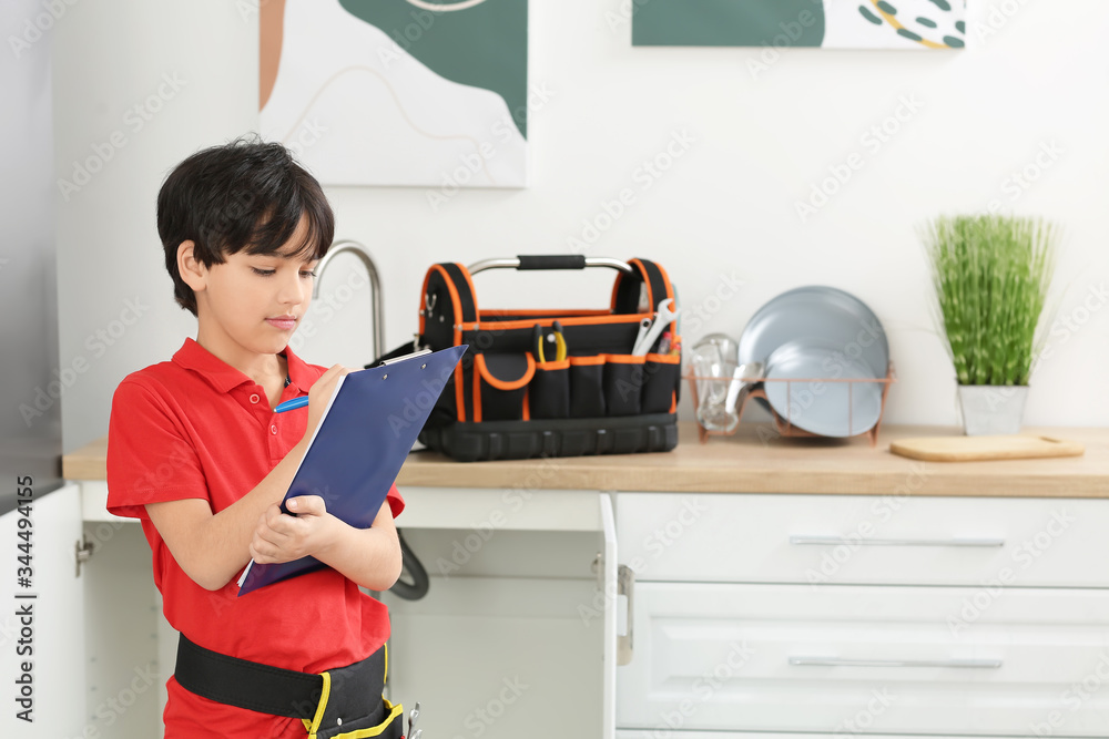 Portrait of little plumber in kitchen