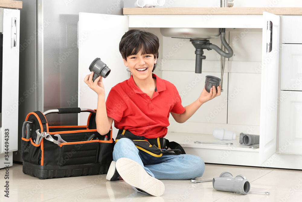 Portrait of little plumber in kitchen