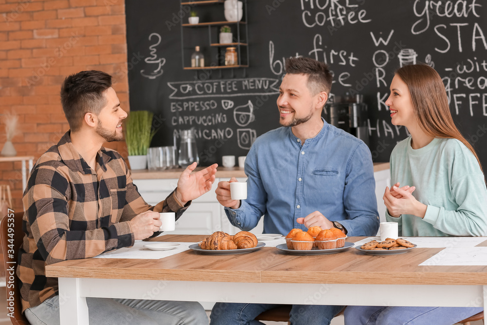 Colleagues drinking coffee in kitchen of office