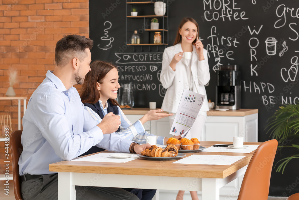 Colleagues drinking coffee in kitchen of office