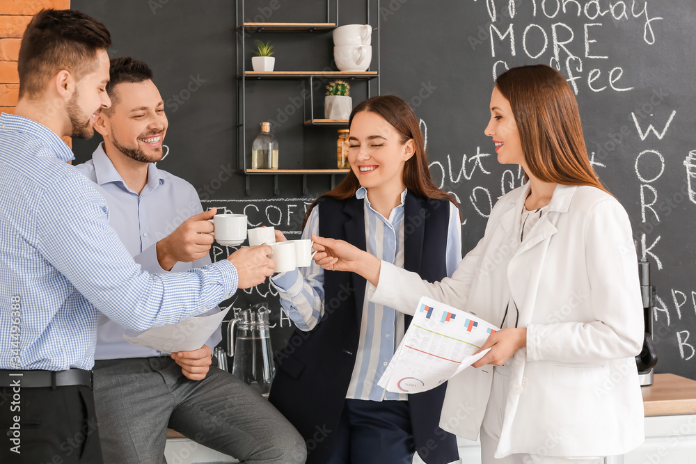 Colleagues drinking coffee in kitchen of office