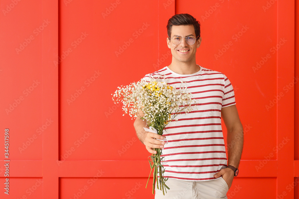 Handsome man with bouquet of flowers on color background