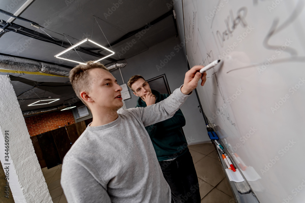 Business young man pointing on white board. Brainstorming concept. Young man explaining plan of work