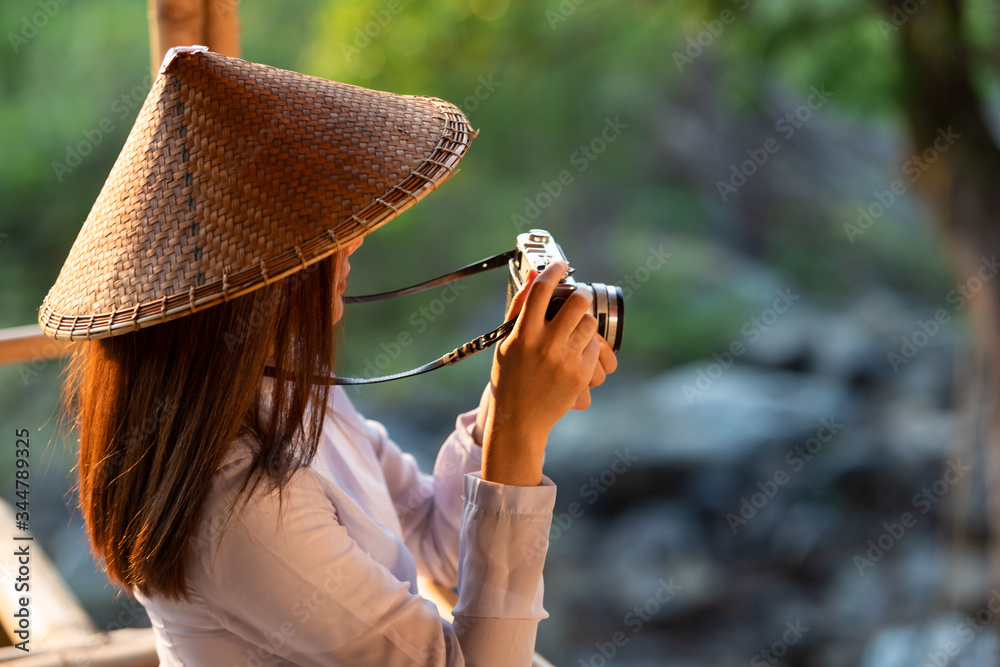 穿着传统服装的越南女孩在大自然中拿着相机