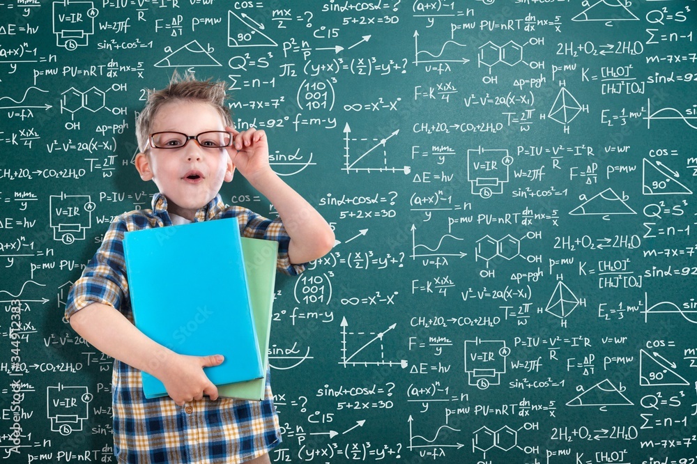 Student boy on blackboard background with formulas