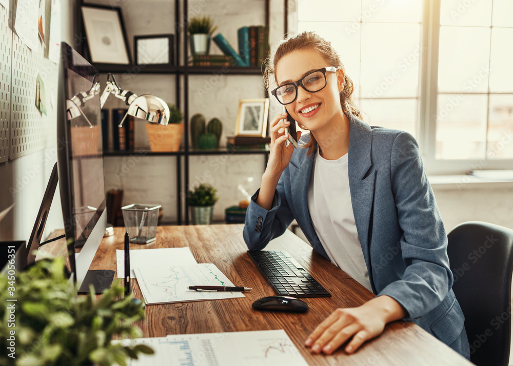 Happy female entrepreneur talking on smartphone