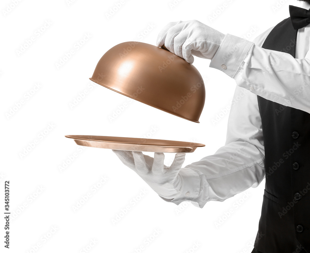 Handsome male waiter with tray and cloche on white background