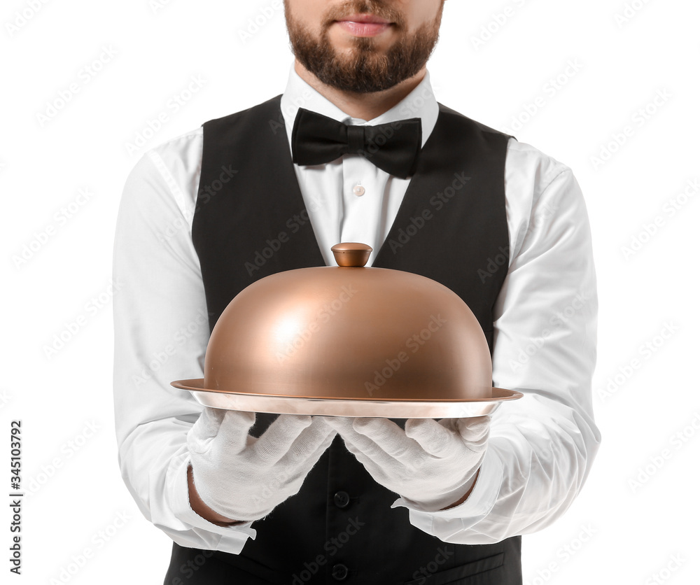 Handsome male waiter with tray and cloche on white background