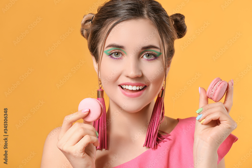 Young woman with beautiful manicure and macarons on color background