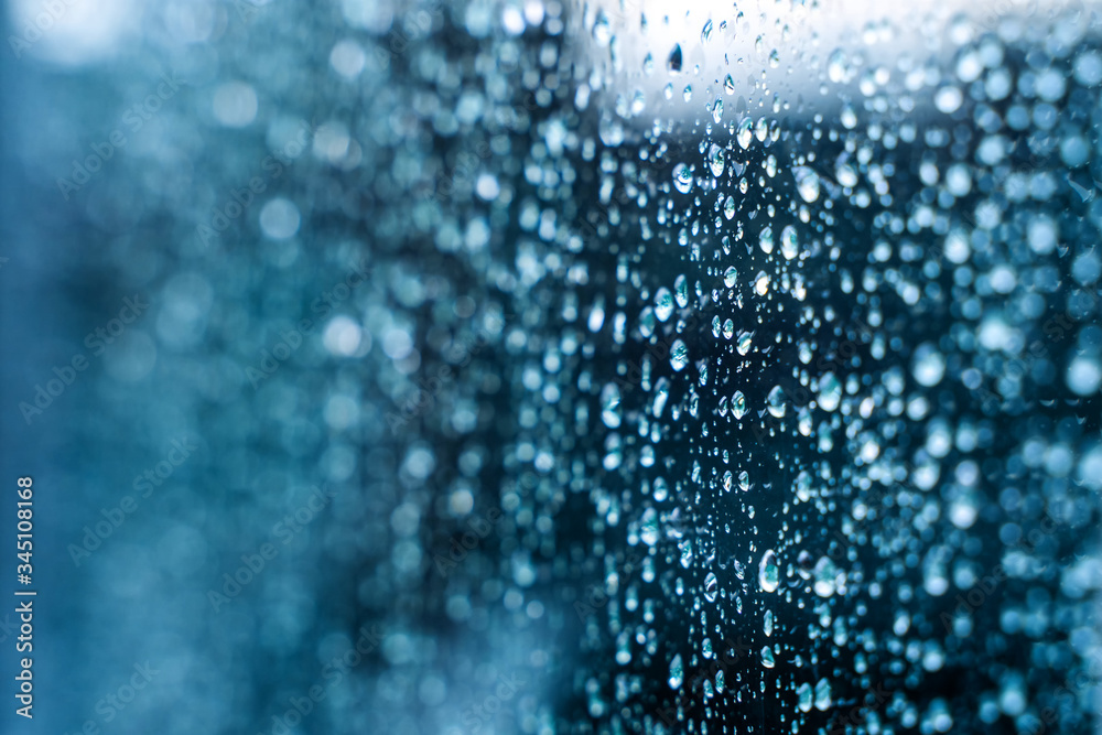 Raindrops on window glass. Selective focus. Rainy city background