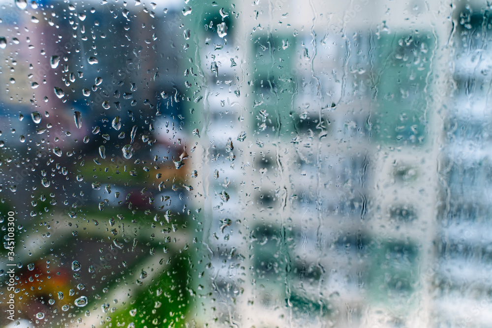 Natural water drop on glass. Selective focus. Rainy city background