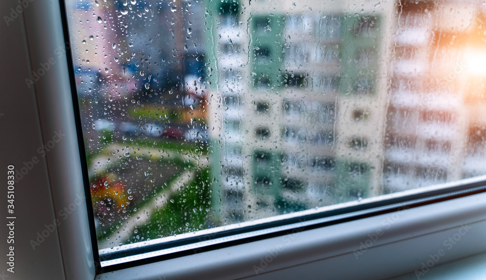 Natural water drop on glass. Selective focus. Rainy city background