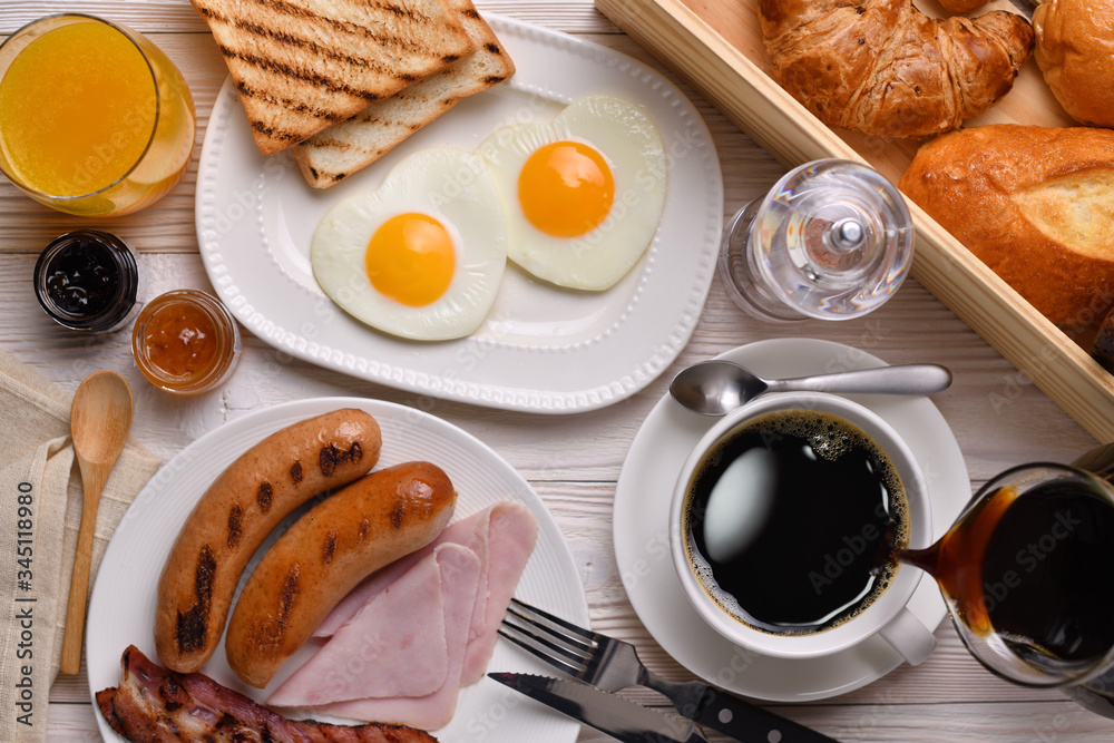 Pouring coffee on a cup with breakfast on wooden table