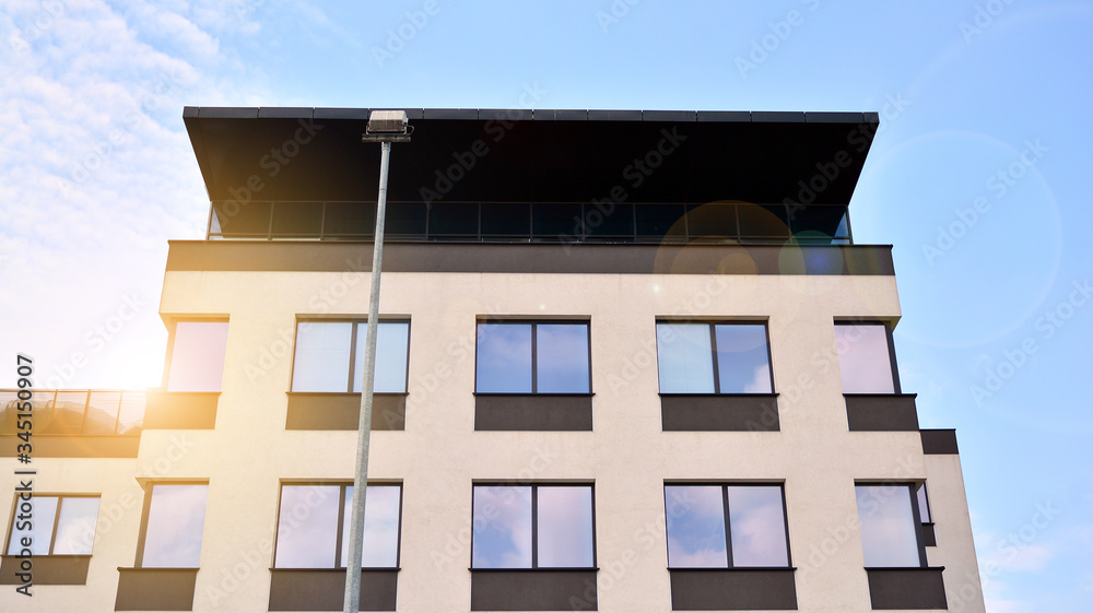 Glass building with blue sky background. Modern office building detail, glass surface clouds reflect