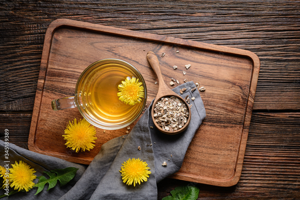 Herbal drink for liver detox, dandelion root tea in a glass cup decorated with fresh flowers