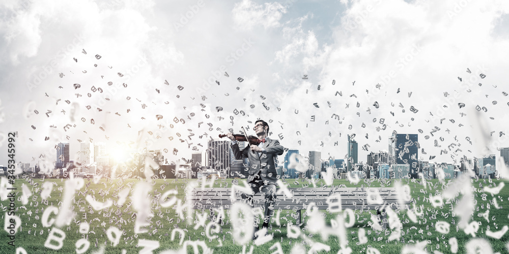 Handsome violinist in park on wooden bench and symbols fly around