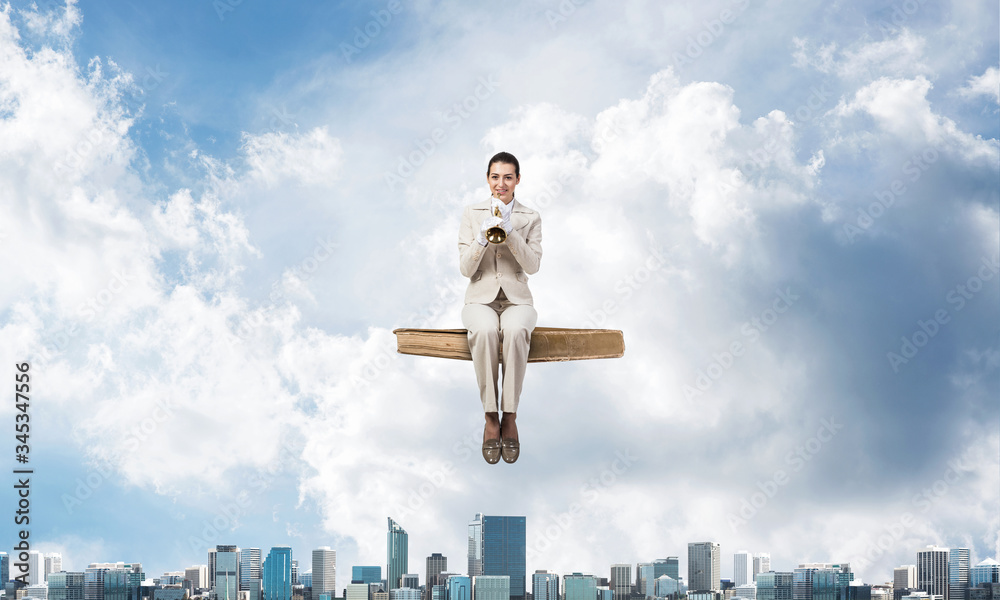 Elegant woman in business suit sitting on book