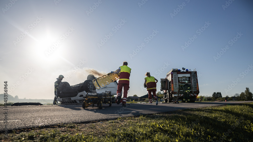 On the Car Crash Traffic Accident Scene: Team of Paramedics and Firefighters Rescue Injured People T