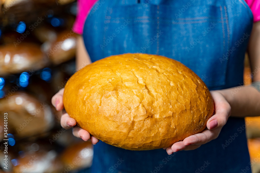 Bread in the hands of a baker. Hot bake from the oven. Industrial production of bread. Bakers hands