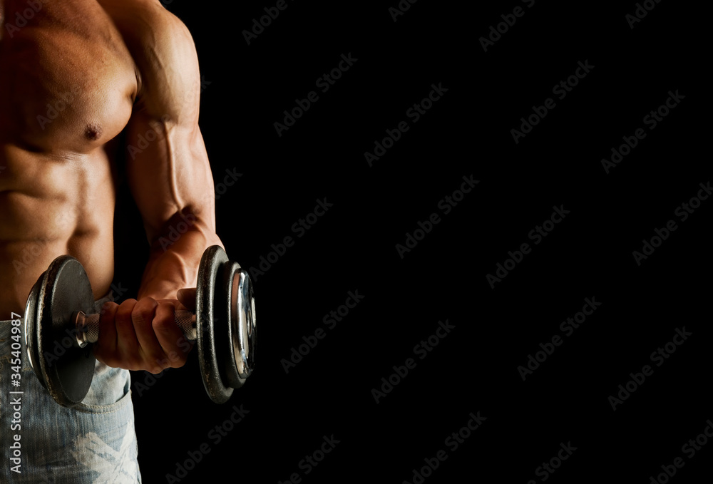 Close-up of a power fitness mans biceps. Muscular bodybuilder guy doing exercises with dumbbell ove