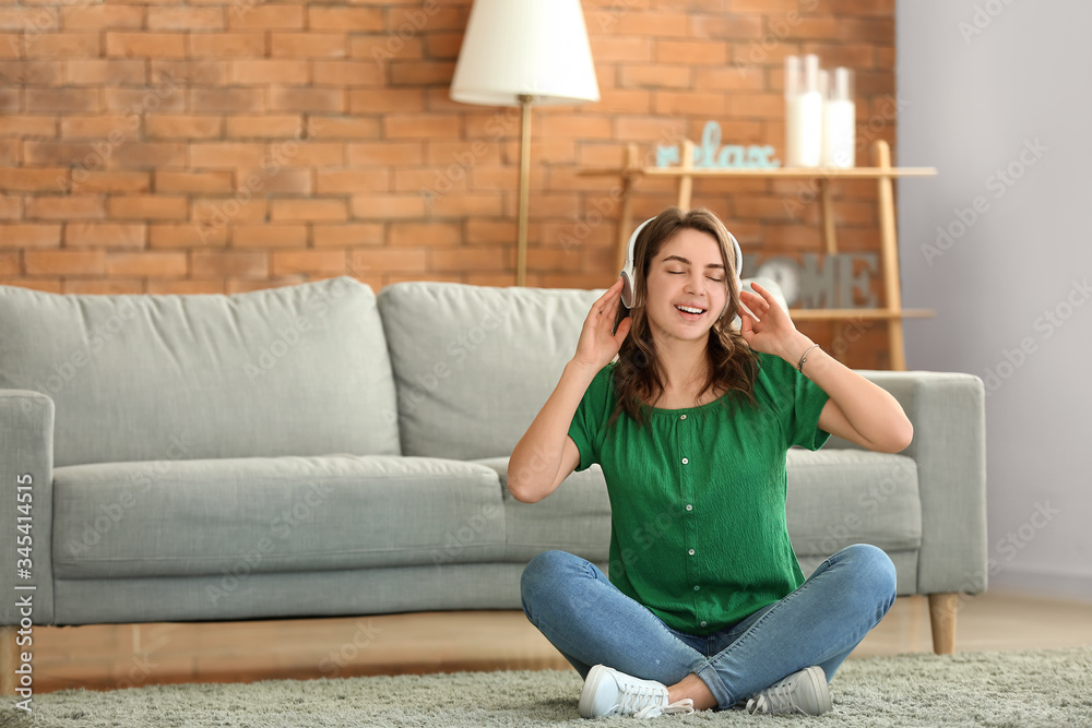 Beautiful young girl listening to music at home