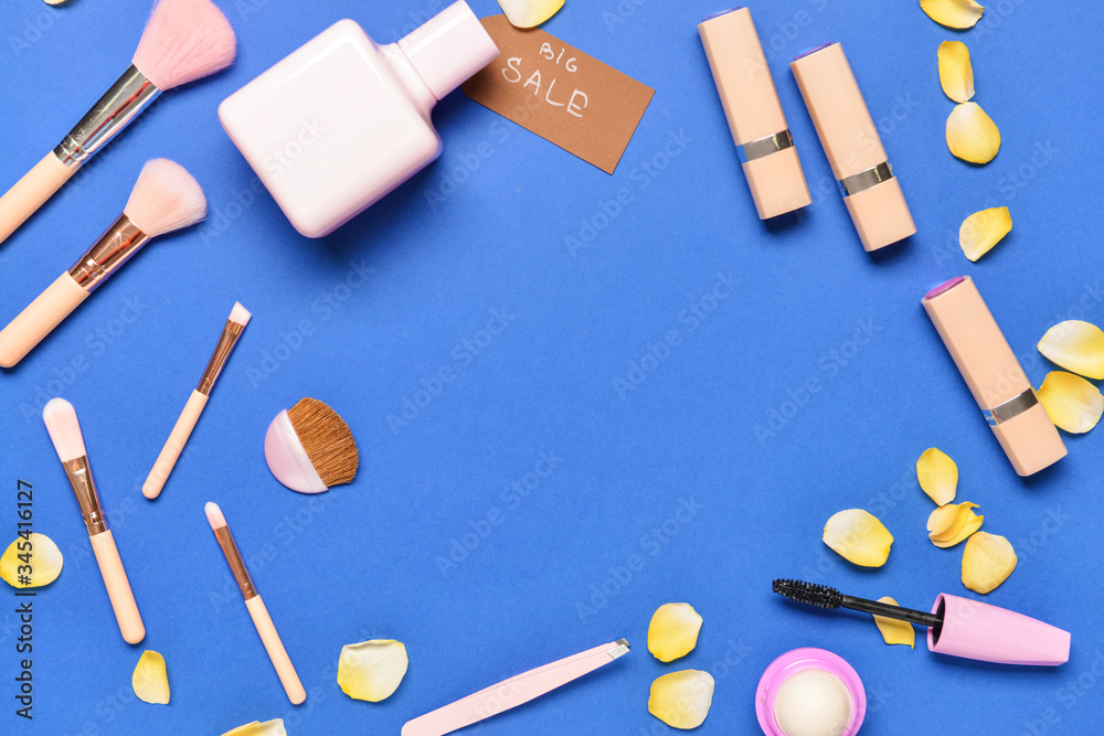 Frame made of perfume and makeup cosmetics on color background