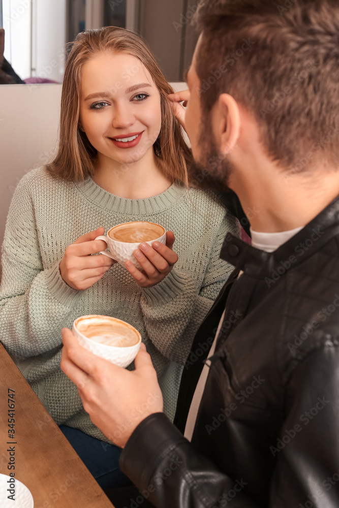 Young couple drinking coffee in cafe