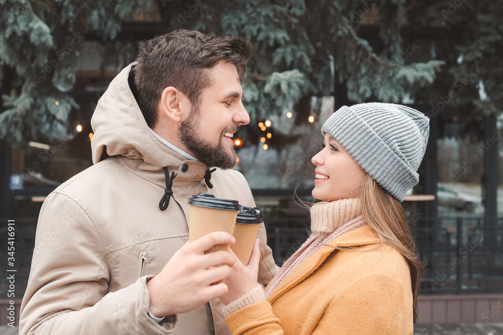 Young couple drinking coffee outdoors